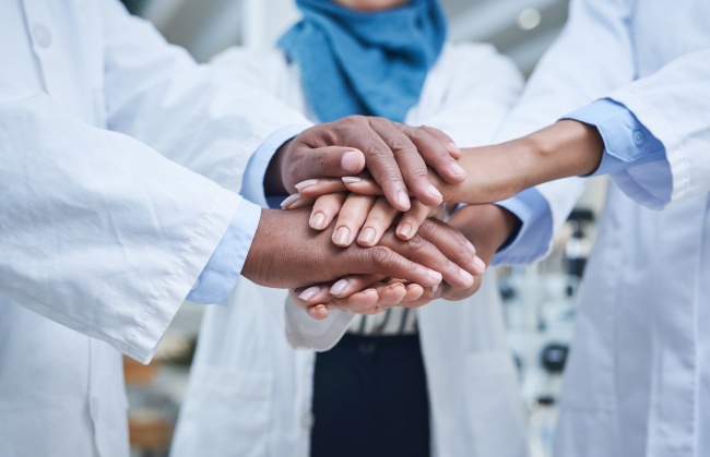 Overlapping hands of research scientists working together on sustainability initiatives and green certification programs
